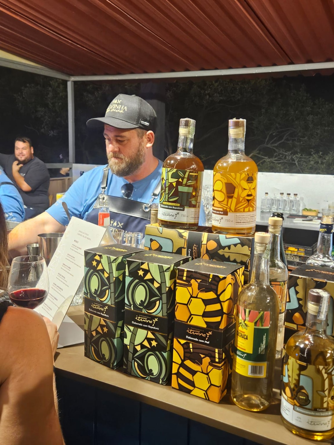 Bartender trabalhando ao lado de uma seleção de cachaças Ituana